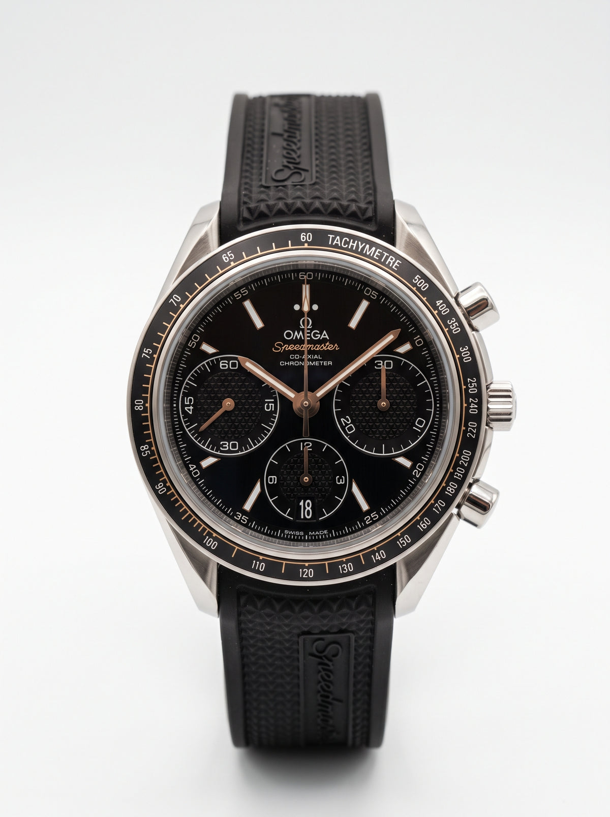 Omega Speedmaster Racing Co-Axial 326.32.40.50.01.001 sur fond blanc, cadran noir et bracelet en caoutchouc.