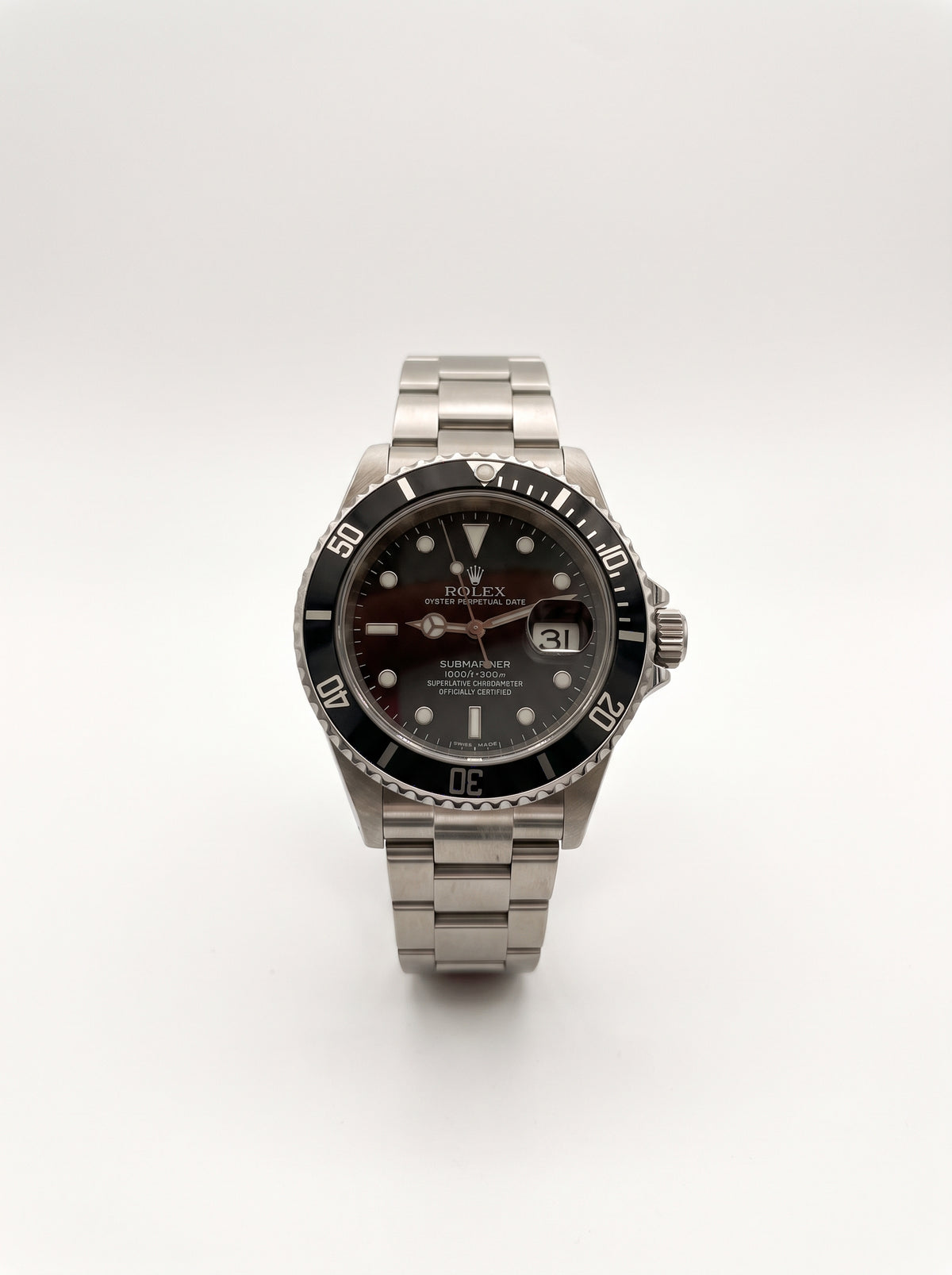 Rolex Submariner Date 16610LN vue de face, cadran noir, lunette noire et guichet de date avec loupe Cyclope.