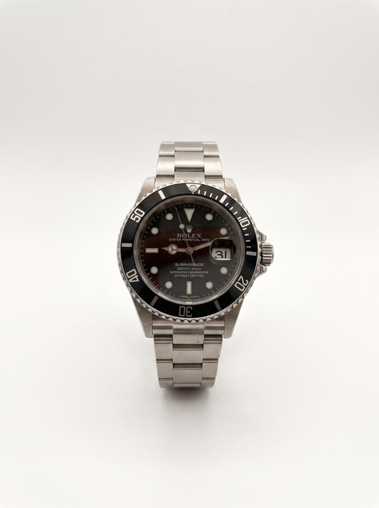 Rolex Submariner Date 16610LN vue de face, cadran noir, lunette noire et guichet de date avec loupe Cyclope.